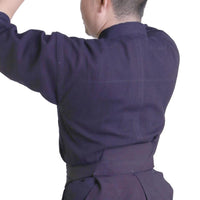 Dogi worn, seen form the back with arms raised.